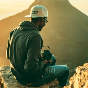 A Captured client sitting on the side of a mountain with their camera
